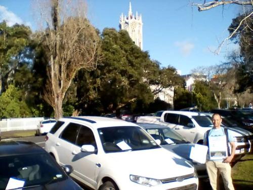2018 - Wayne putting W-BAD flyers under windscreen wipers of cars lining the street outside Auckland University