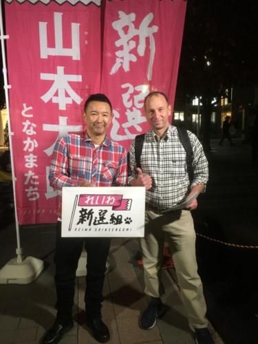 2019 - Wayne gives thumbs up with Japanese politician - celebrity, Yamamoto Taro, at political rally